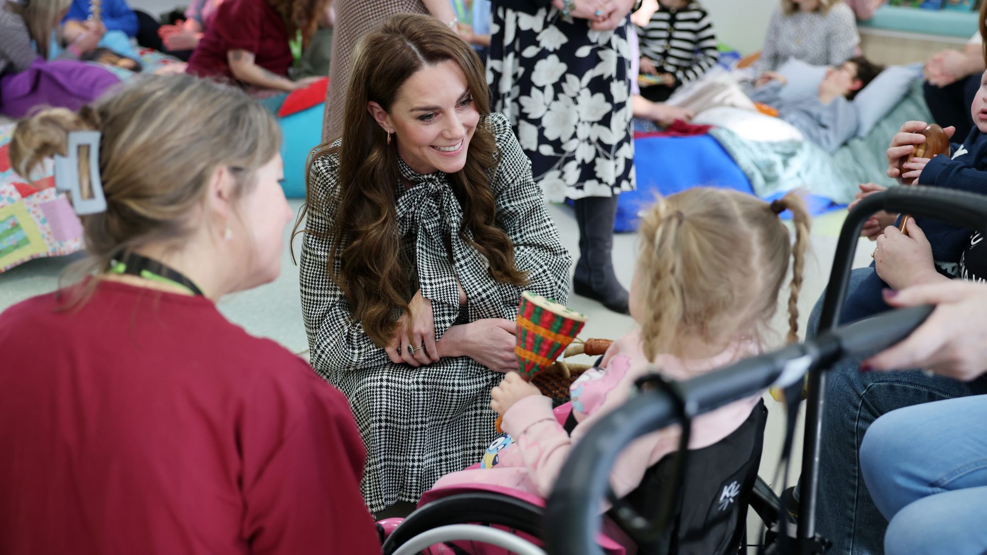 Kate smiling at little girl at children's hospice