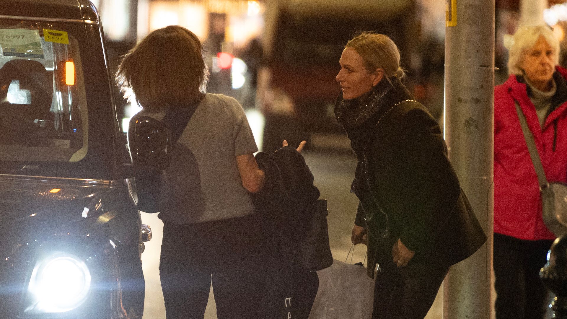 Zara Tindall looking on as a friend gets into a taxi