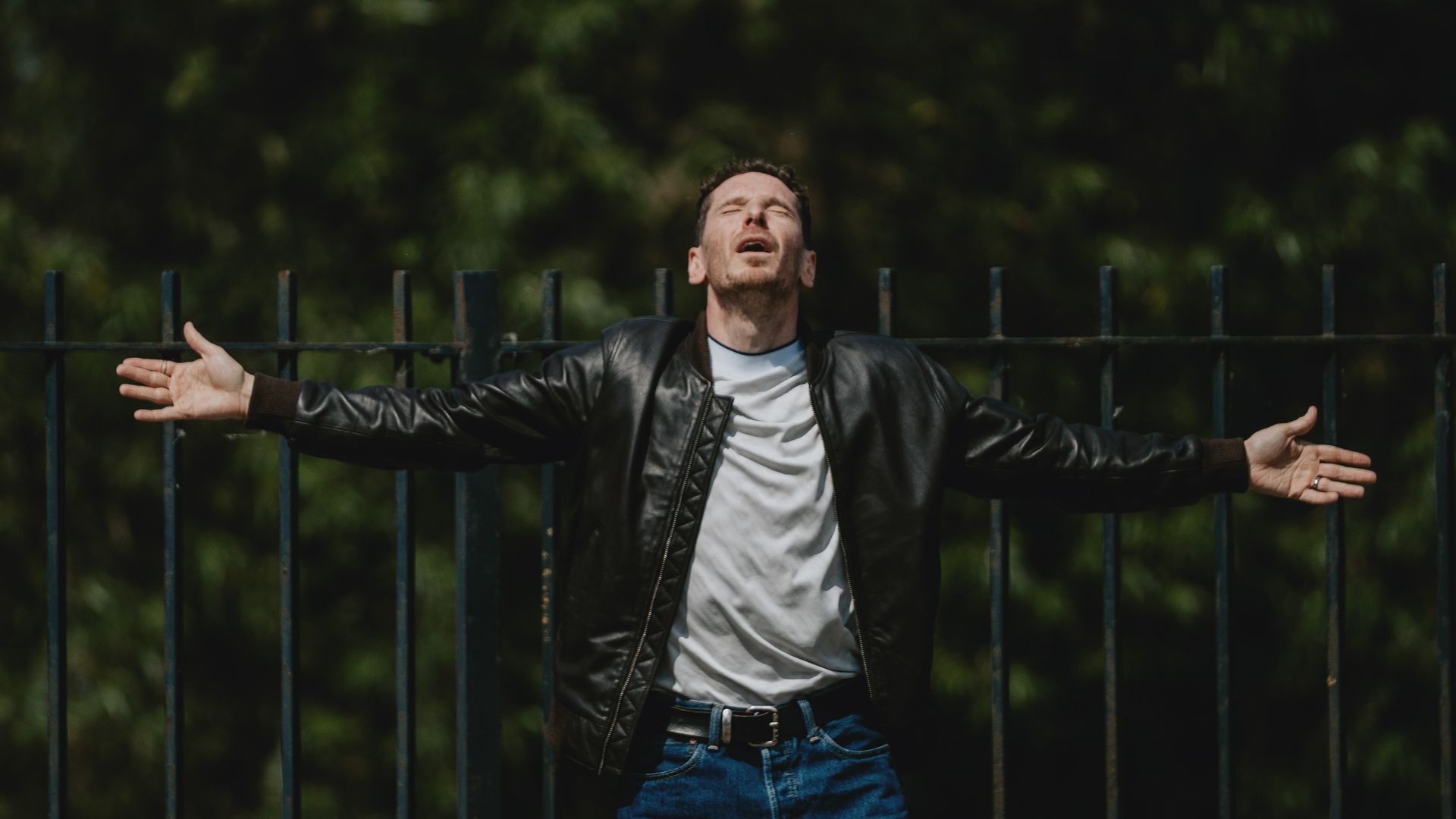 Gerard Kearns in a leather jacket with his arms outstretched in a scene from Waiting for the Out