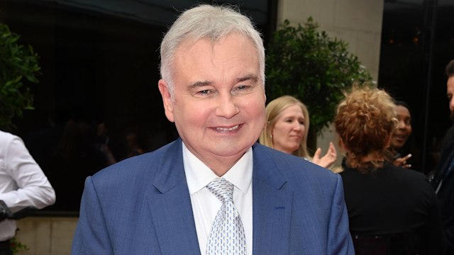 Eamonn Holmes in blue suit with crutches