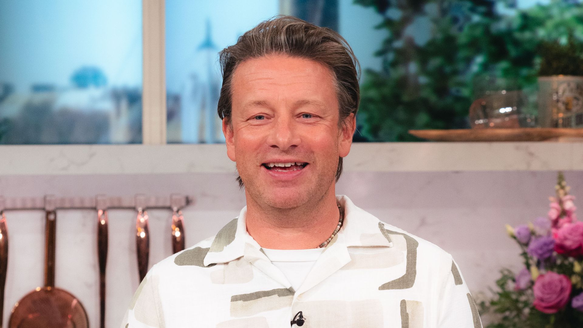 Jamie Oliver in This Morning kitchen in printed white and beige shirt