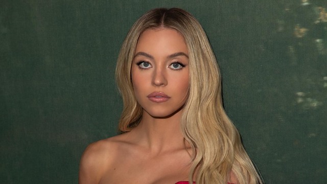 Sydney Sweeney poses in a red off the shoulder dress for Christmas 2023