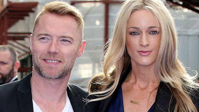 Ronan Keating in a black suit and Storm in a blazer in the sunshine