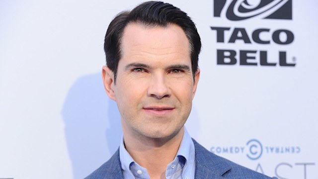Jimmy Carr poses for photographers in front of step and repeat wall at Los Angeles event