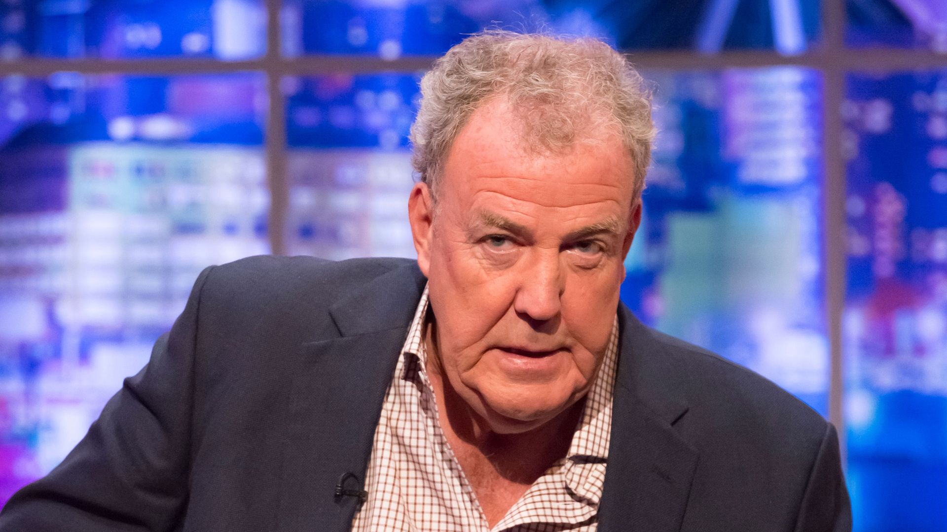 Jeremy Clarkson looking concerned while sitting on a sofa