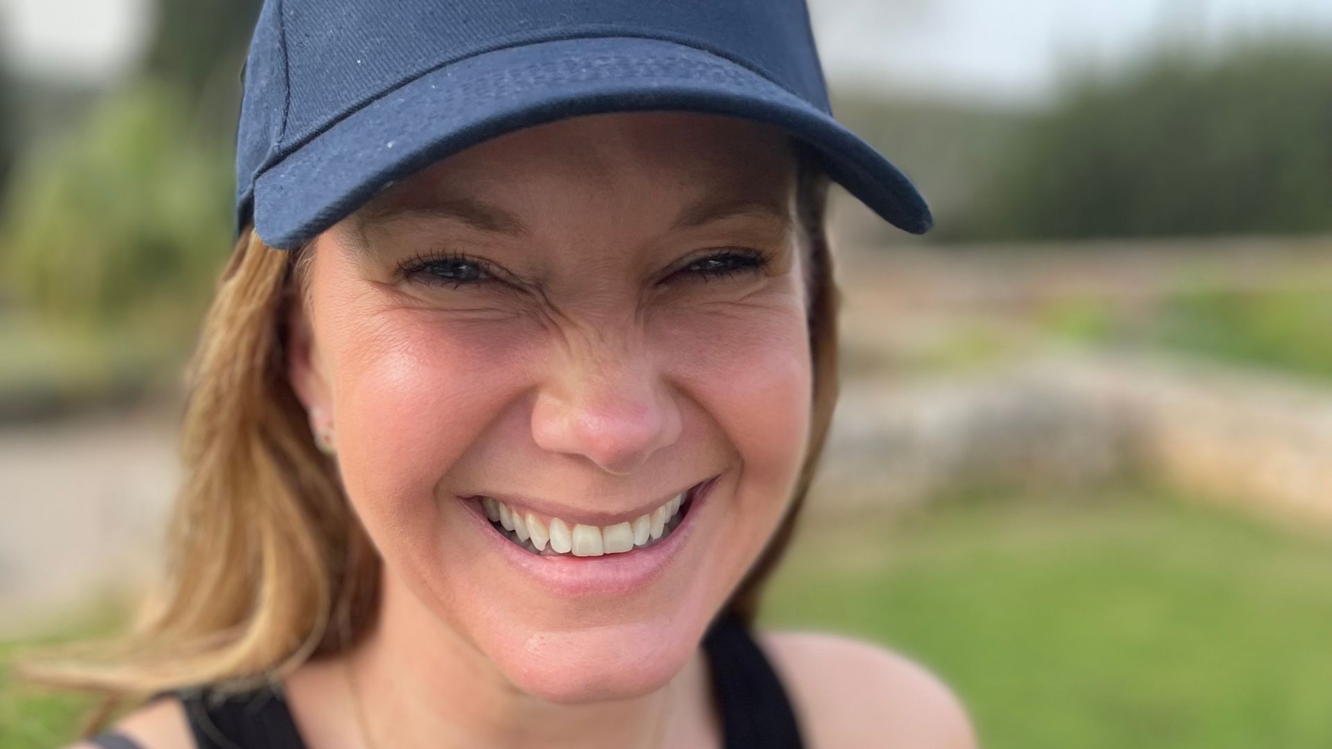 woman in a cap smiling for a selfie