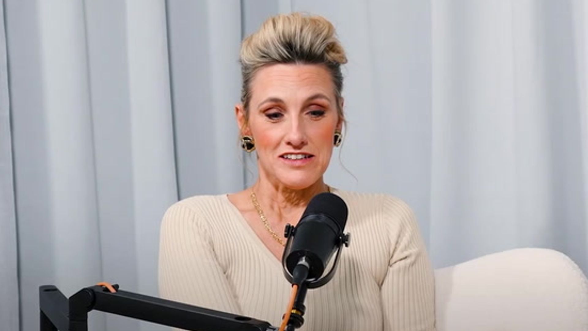A woman sits in front of a mic
