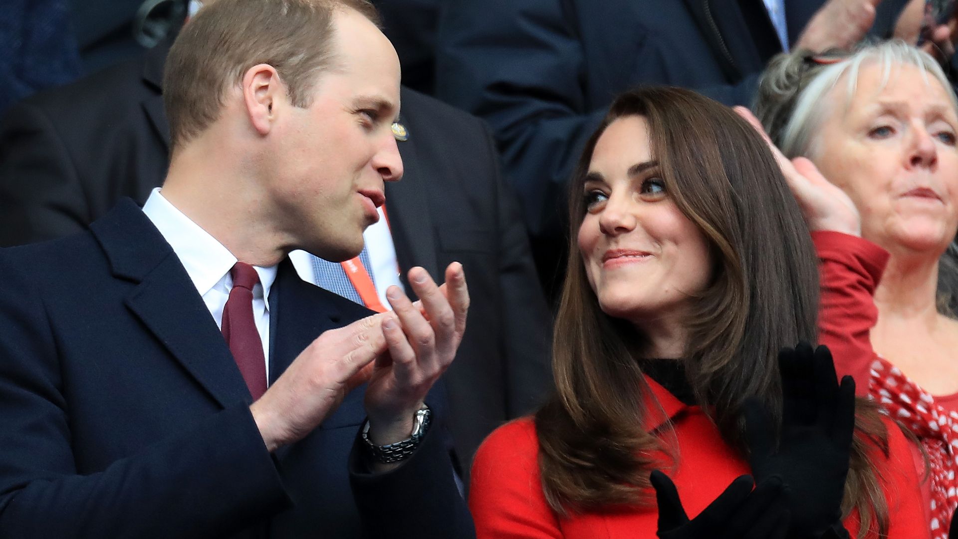 couple clapping at rugby match