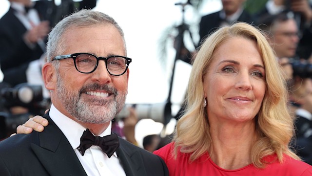 husband and wife smiling on red carpet, close-up