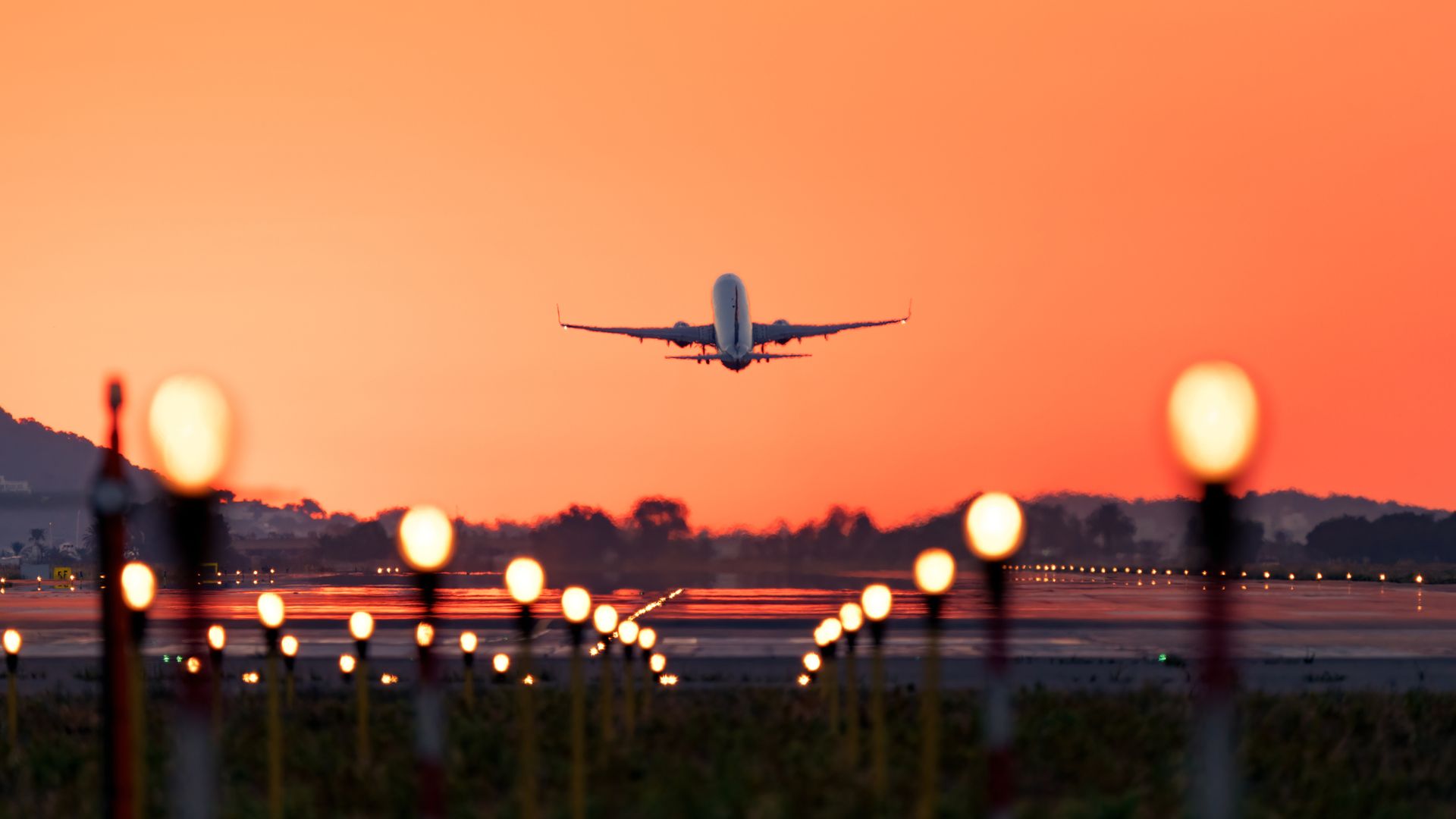 Airplane taking off at sunrise