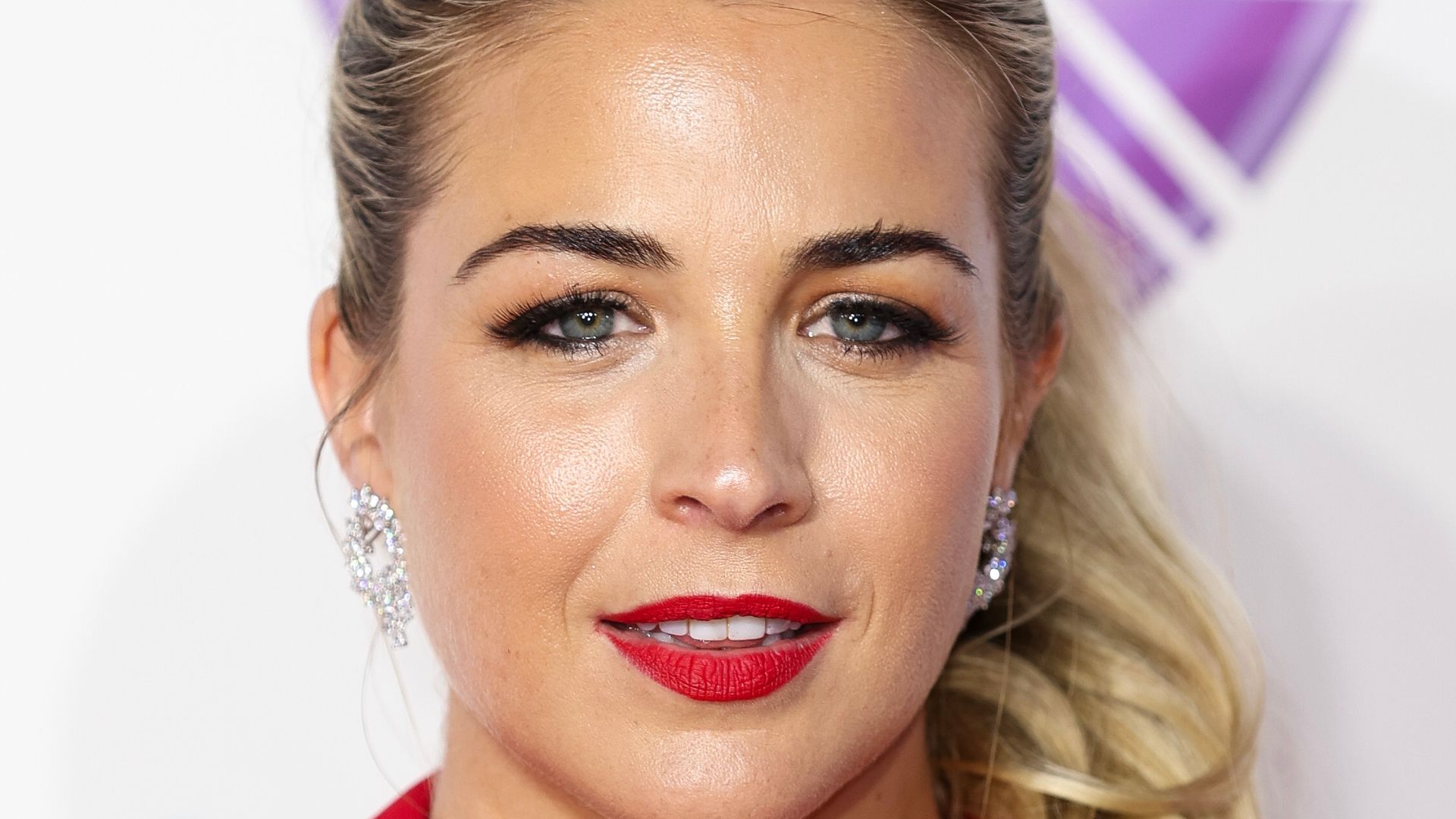 Gemma Atkinson wearing a red suit and red lip with hair up