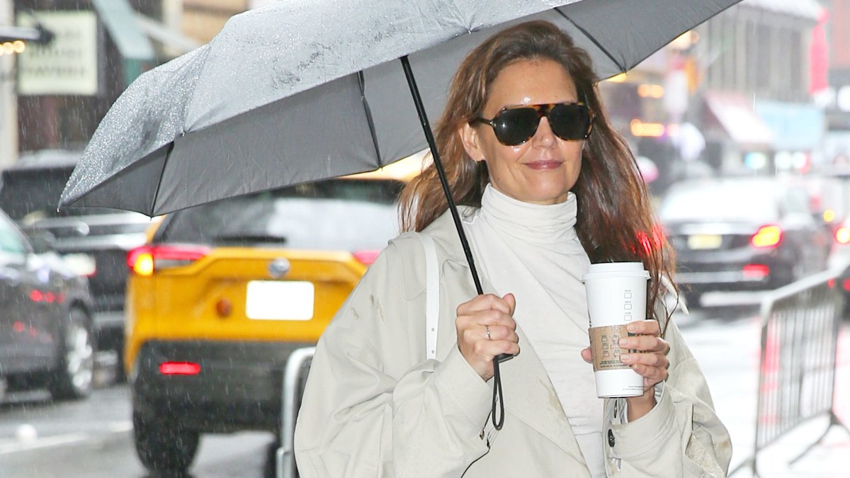 Katie Holmes luce elegante en la ciudad con una gabardina y botas de piel de serpiente cuando llega a su actuación matinal.