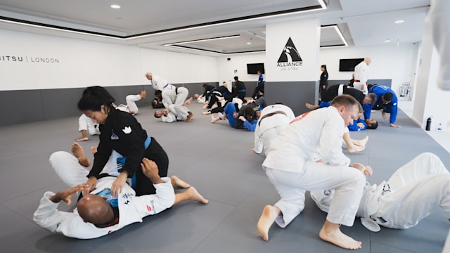 Jiu jitsu students grappling in class