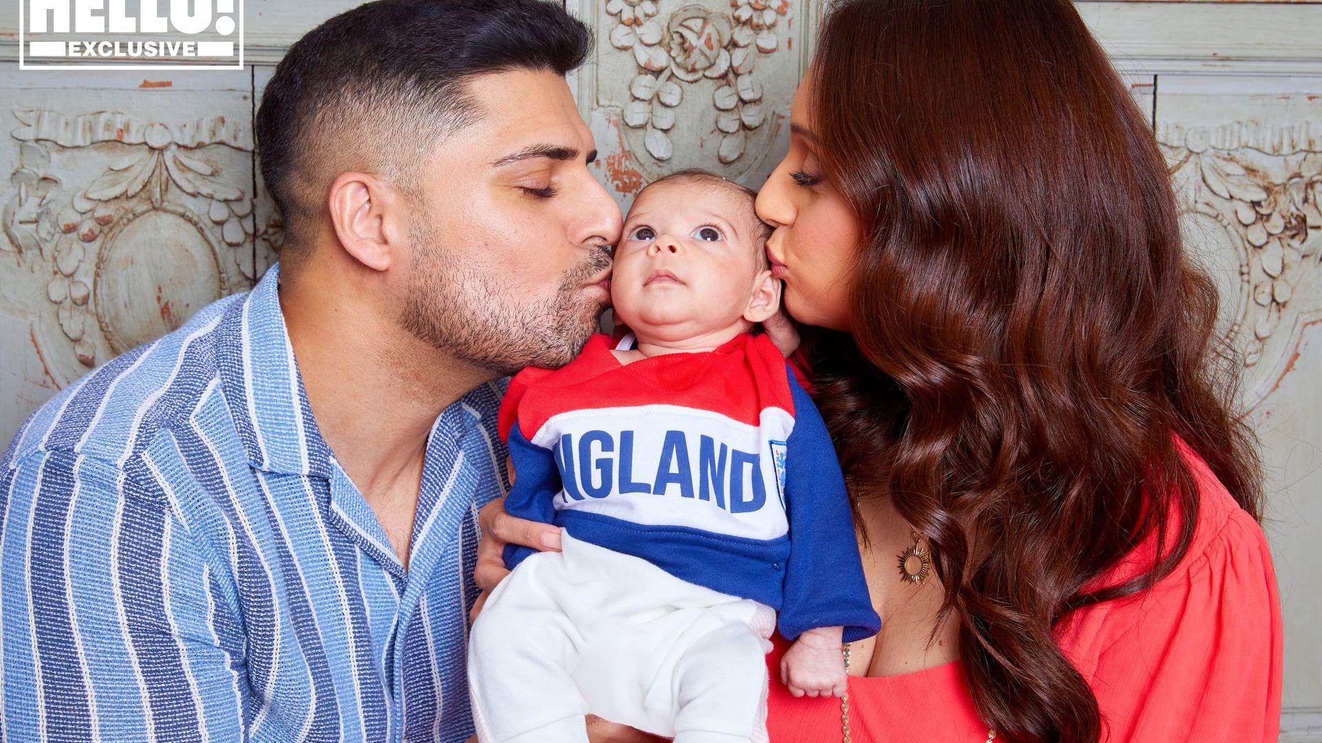 Seema Jaswal kisses her newborn baby as she poses with her husband