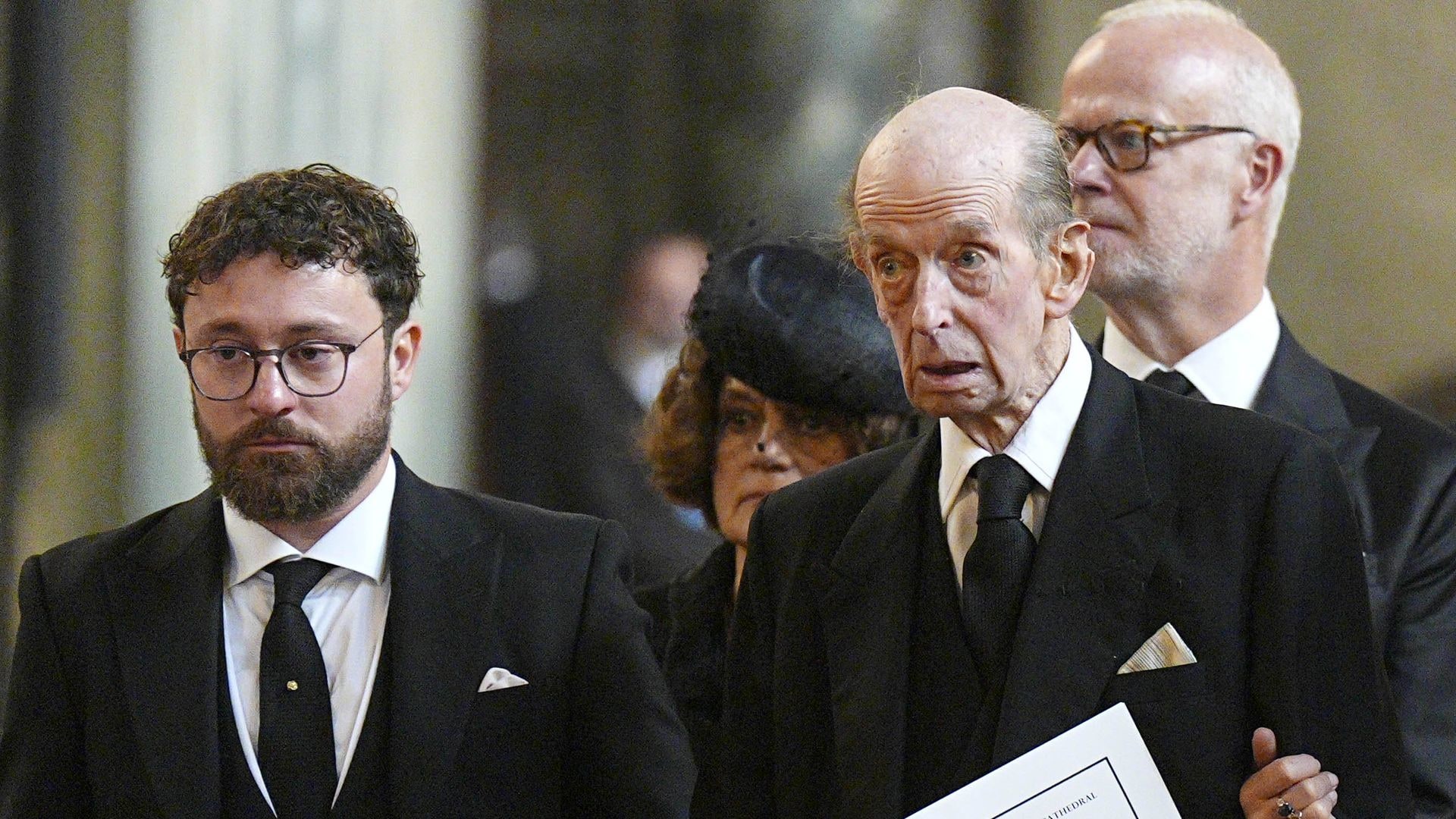 Prince Edward, Duke of Kent leaves the Requiem Mass service for the Duchess of Kent with his grandson, Lord Downpatrick