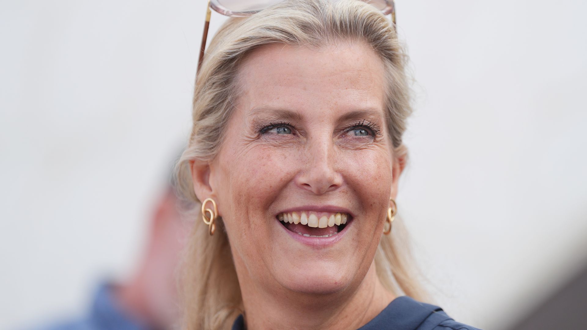 The Duchess of Edinburgh in navy dress shoulders up smiling