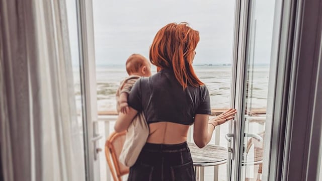 stacey dooley holding daughter minnie on terrace overlooking sea