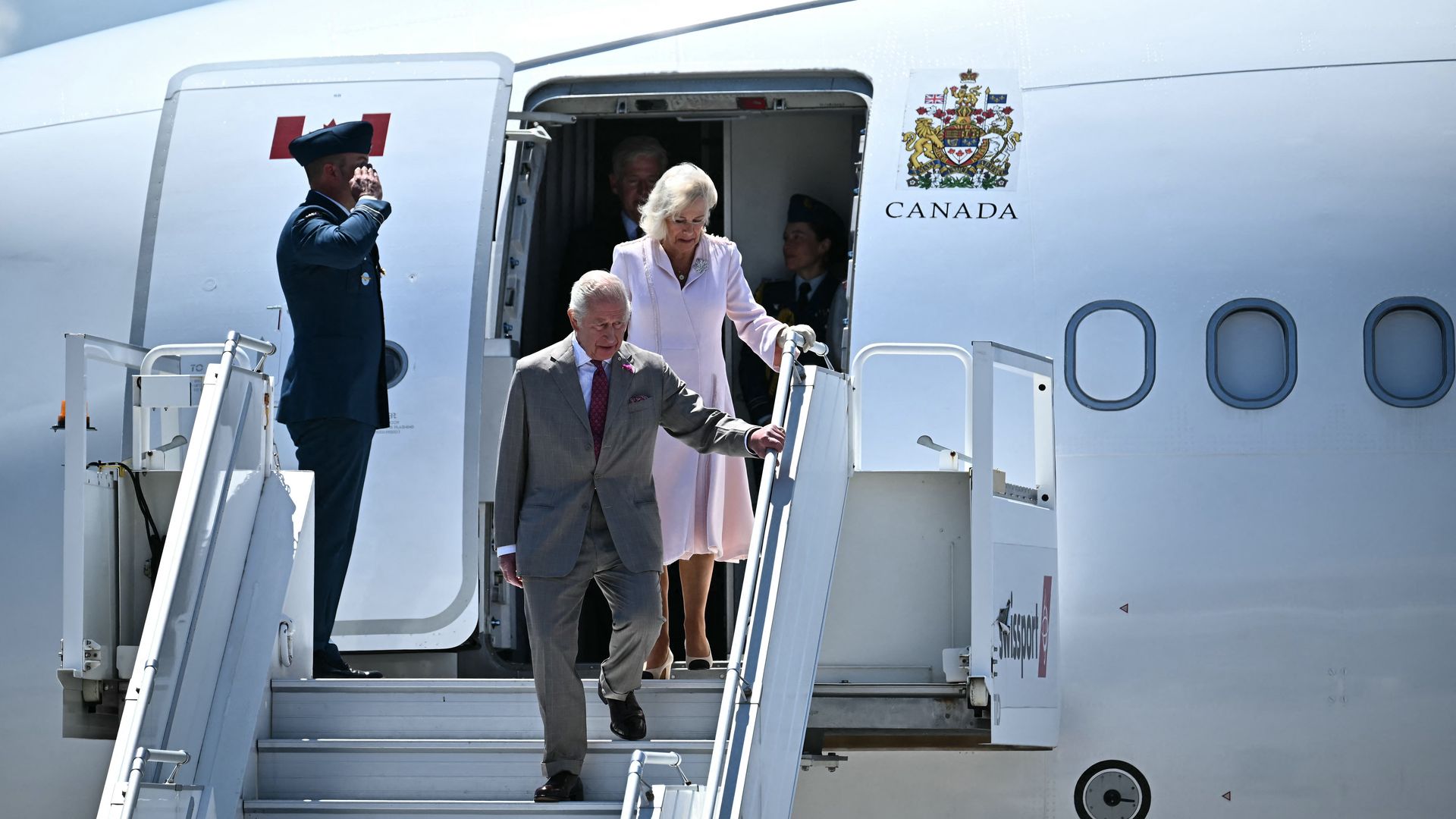 King Charles and Queen Camilla getting off of a plane