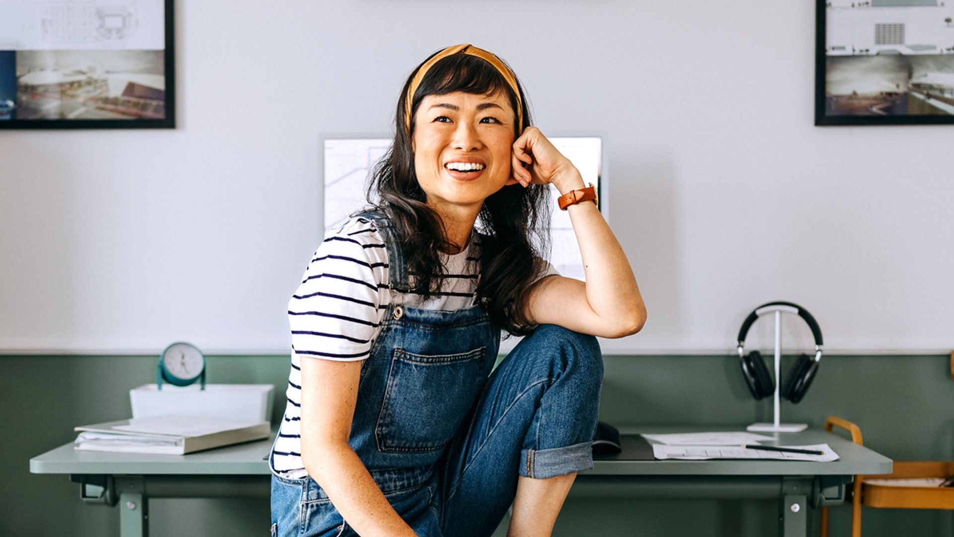 Portrait of cheerful casually clothed beautiful woman sitting at the desk at home office