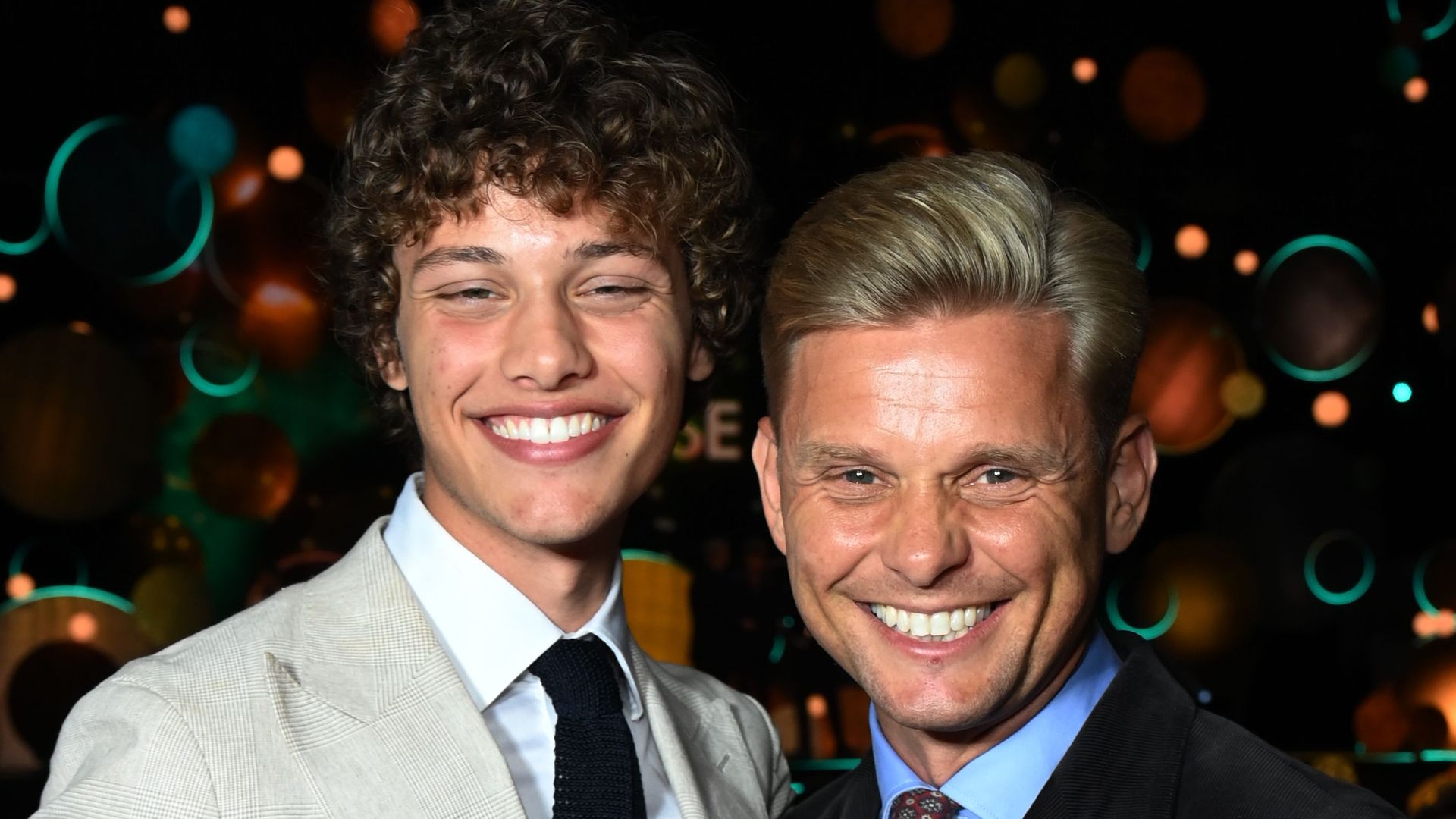 Bobby Brazier in a white suit jacket with father Jeff Brazier in a black jacket