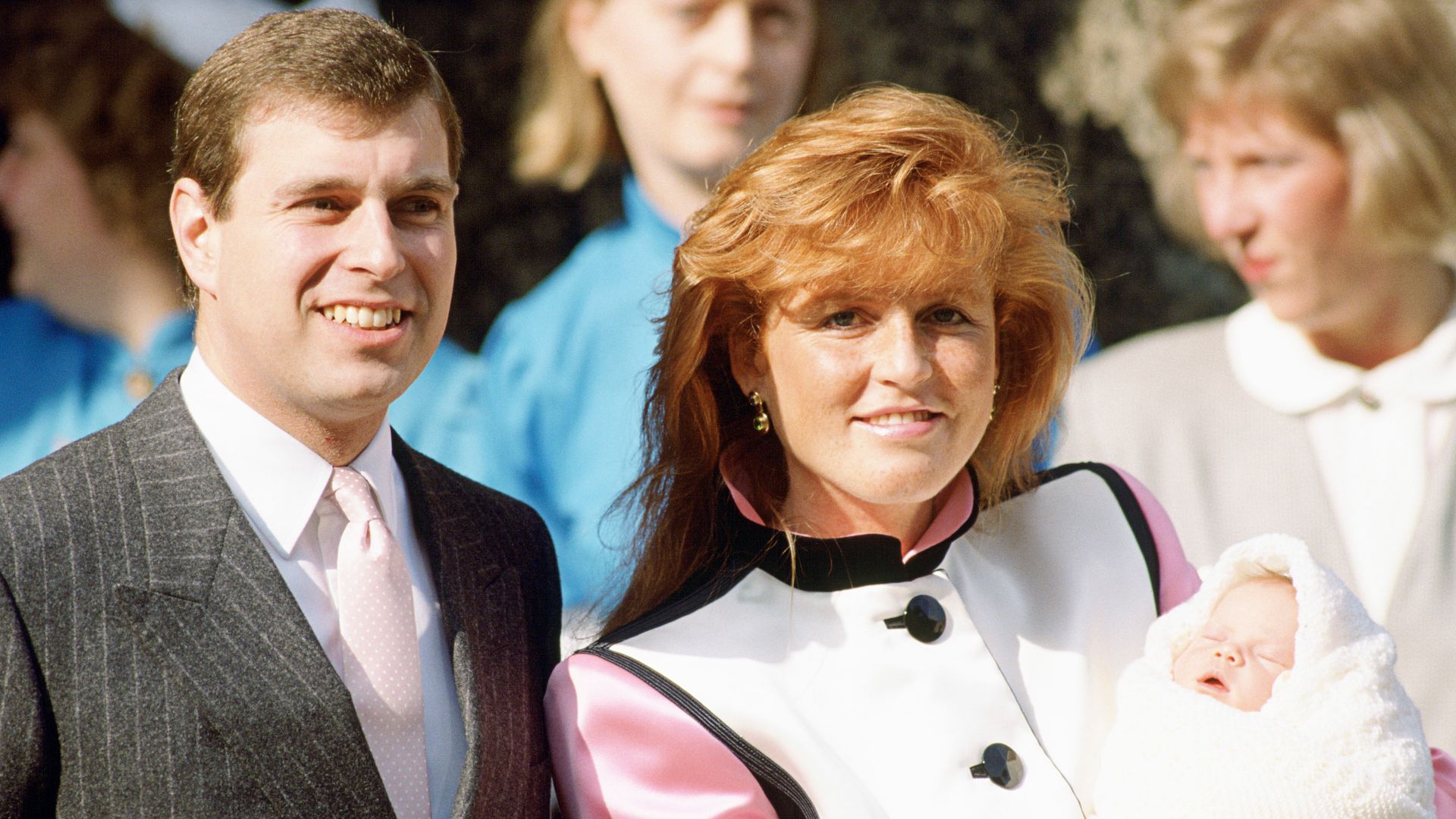 Prince Andrew standing with Sarah Ferguson holding a baby Princess Eugenie
