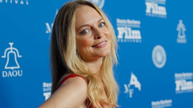 Heather Graham posing and smiling in red dress