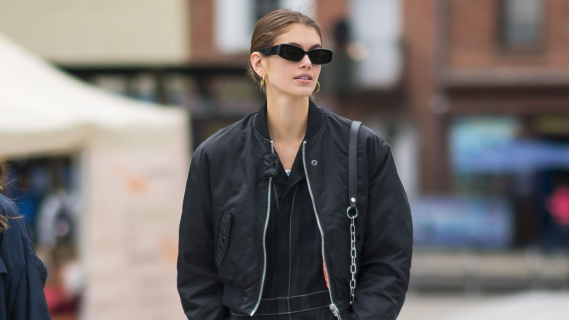 kaia gerber in all black outfit and red sneakers