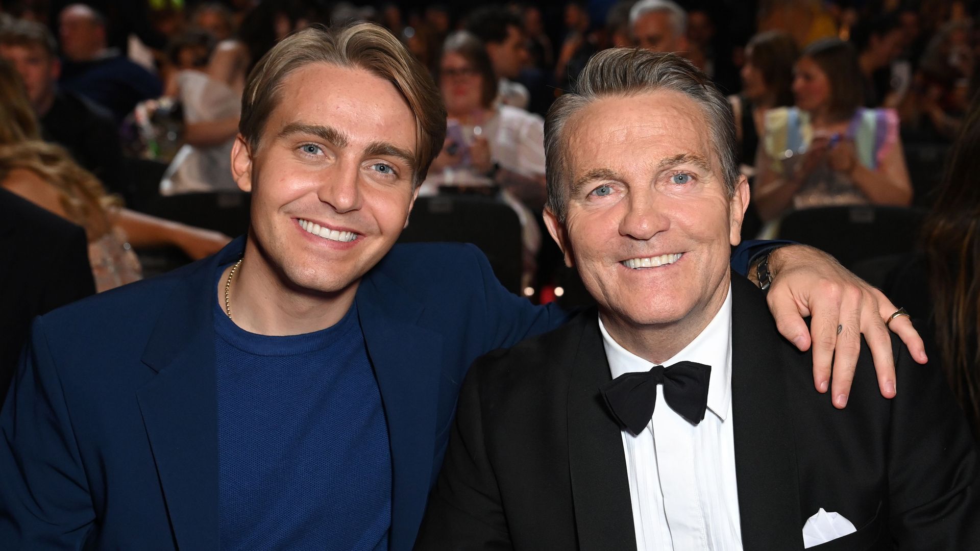 man and son smiling for photo in suits