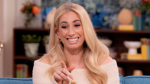 Stacey Solomon in white fluffy jumper dress holding a mug while sitting on the This Morning sofa