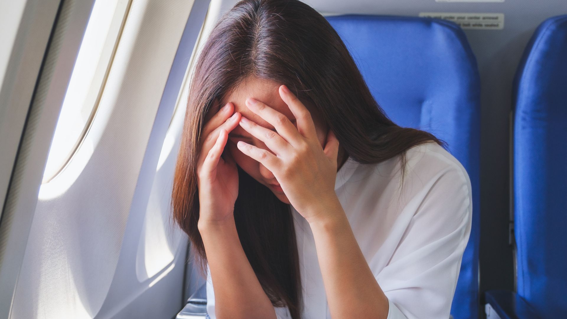 woman on airplane with fear of flying.