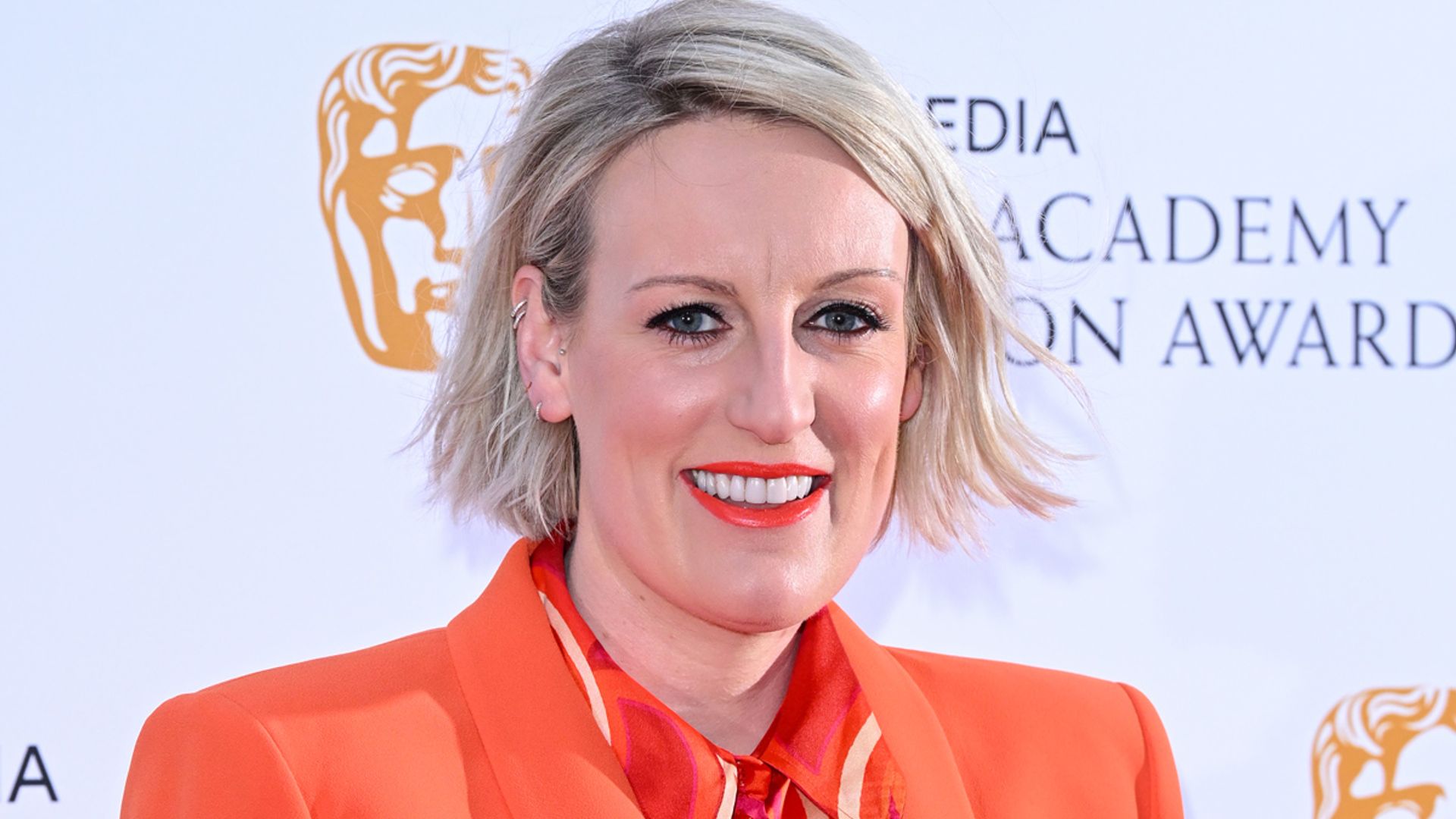 Steph McGovern from Steph's Packed Lunch wearing orange suit lipstick and shirt at BAFTAs