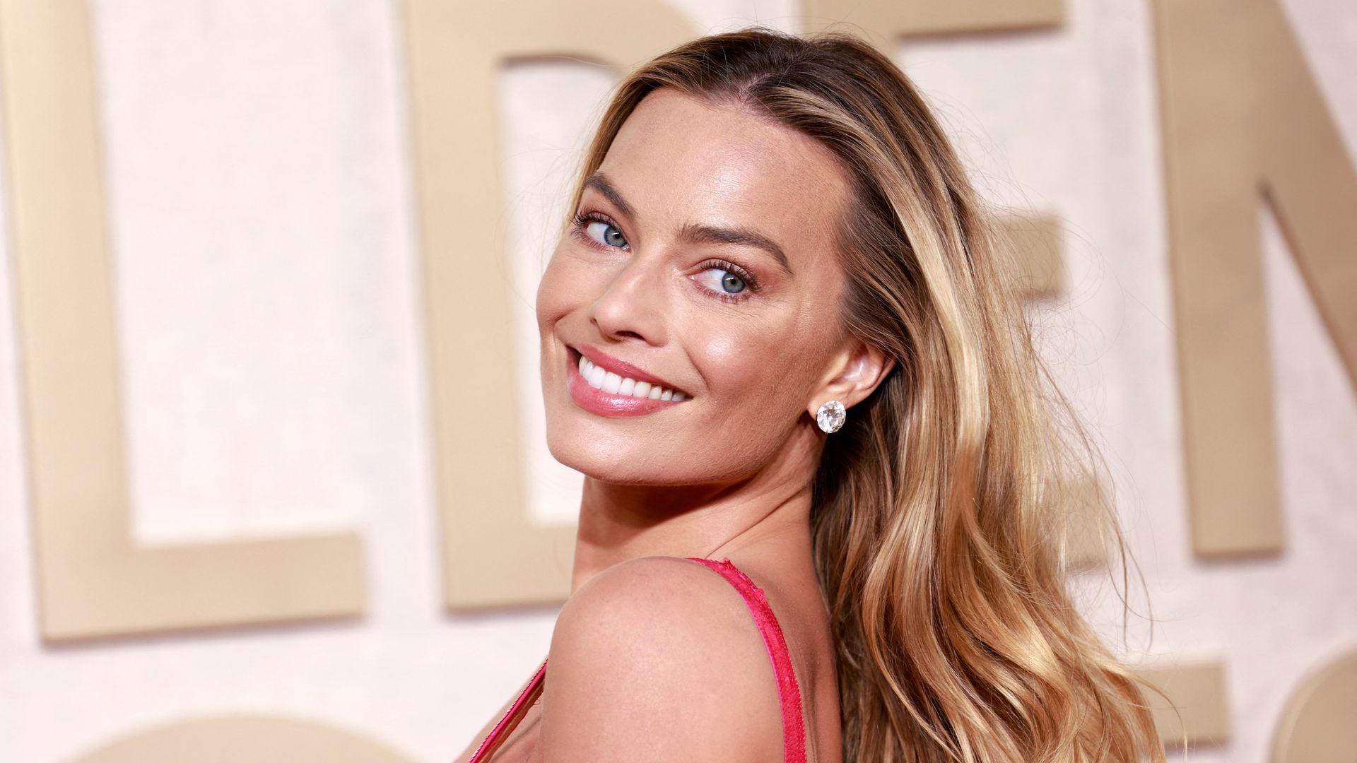 Margot Robbie smiling with glowy skin at the Golden Globes 