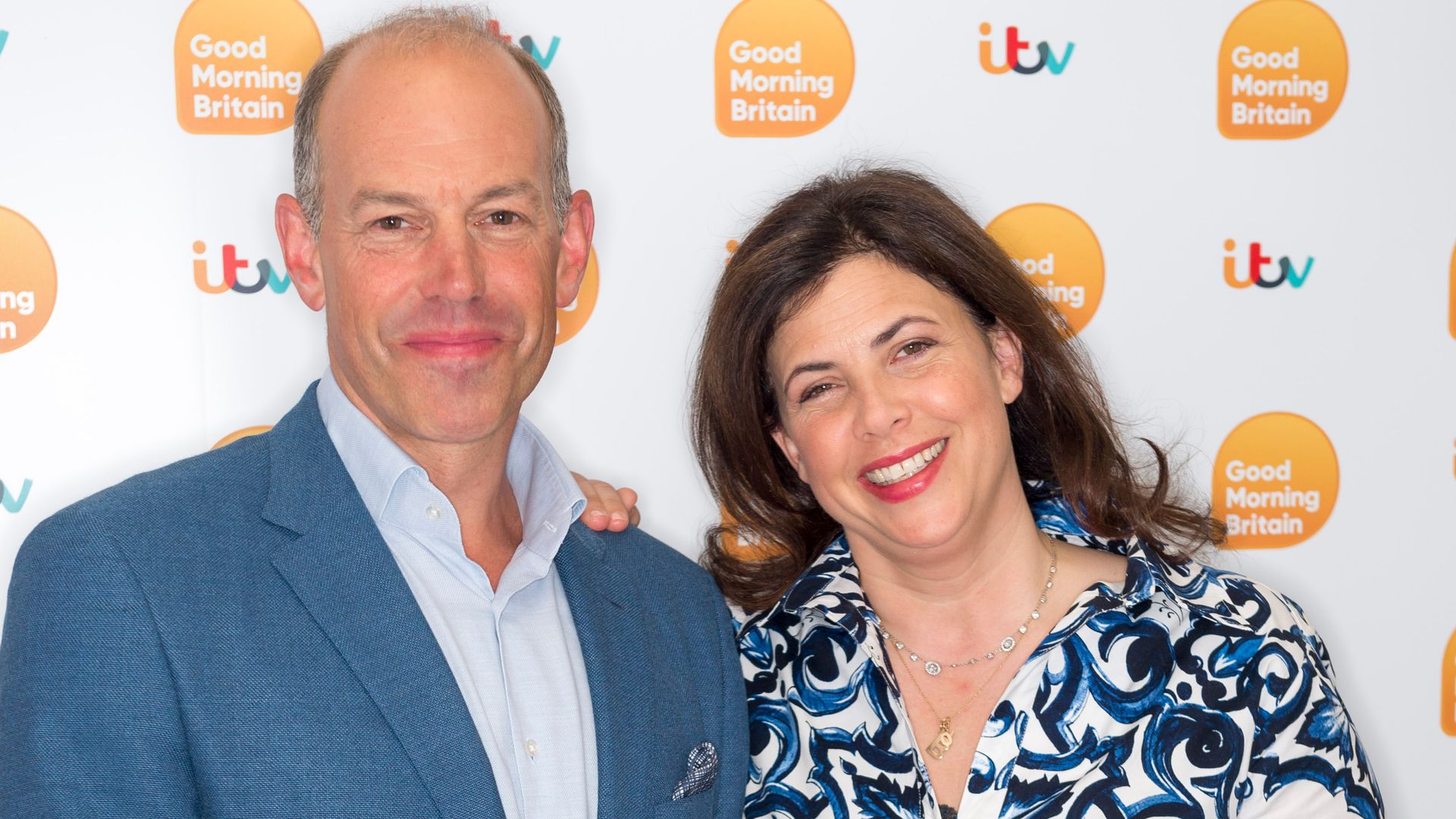 Phil Spencer in a blue suit and Kirstie Allsopp in a blue dress