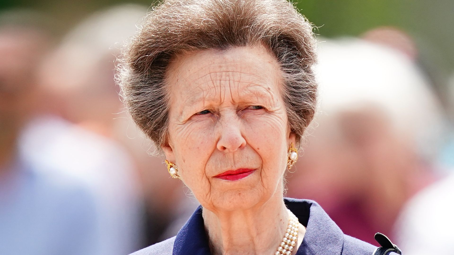 Princess Anne in a blue jacket with red lipstick