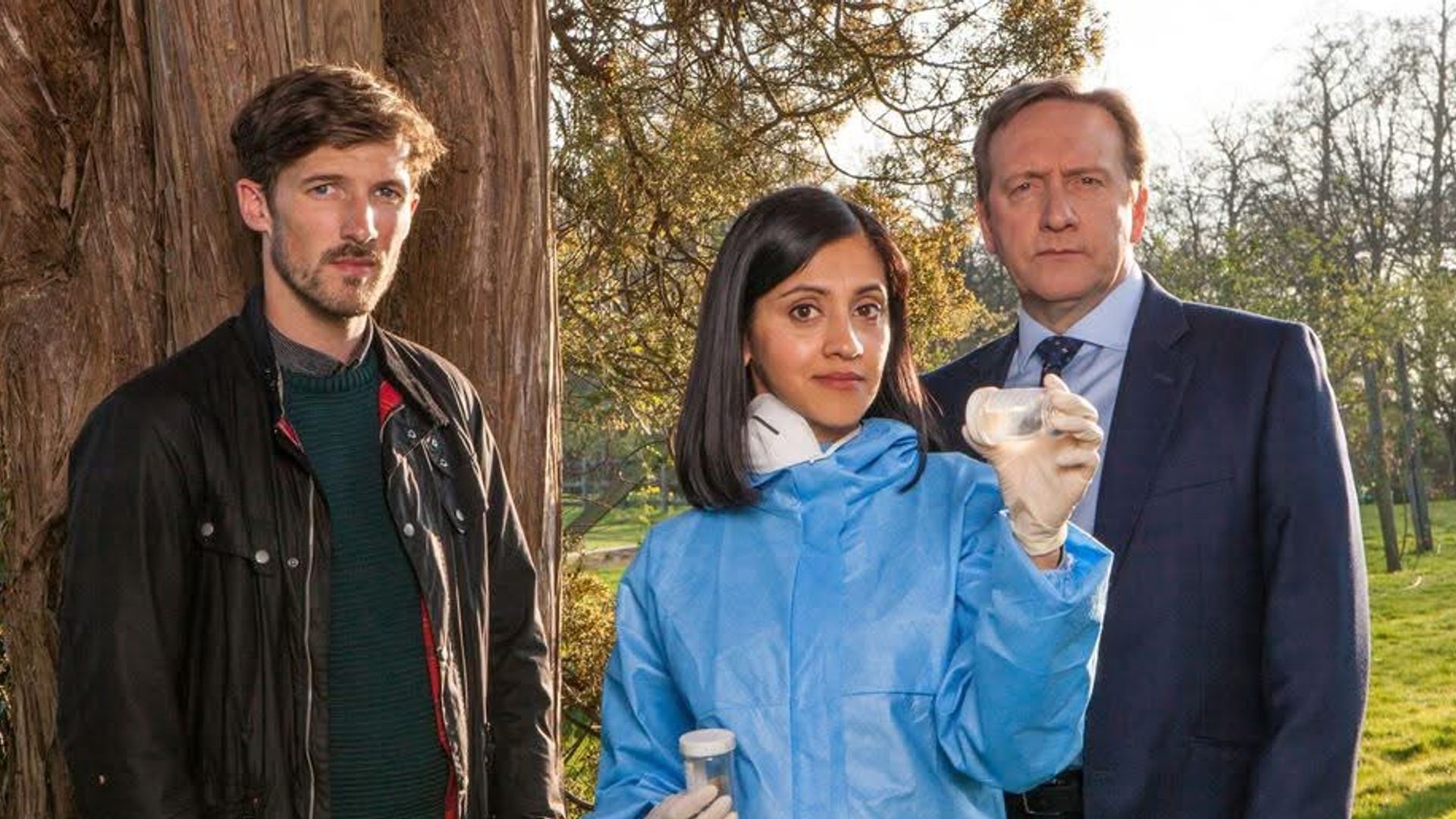 two police officers and forensic pathologist standing in field