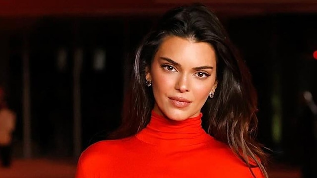 kendall Jenner poses on the red carpet in a red gown