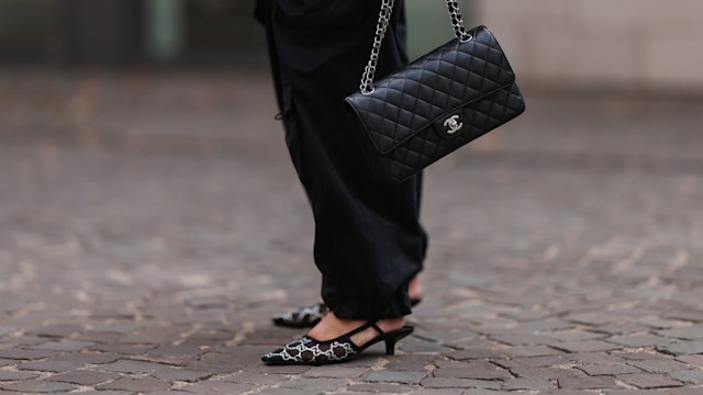 Julia Zwingenberg wearing Balenciaga black logo cap, striped black and beige Arket sweater, Chanel medium black leather flap bag, Preach wide leg pants and Gucci sparkling shiny logo print heels 