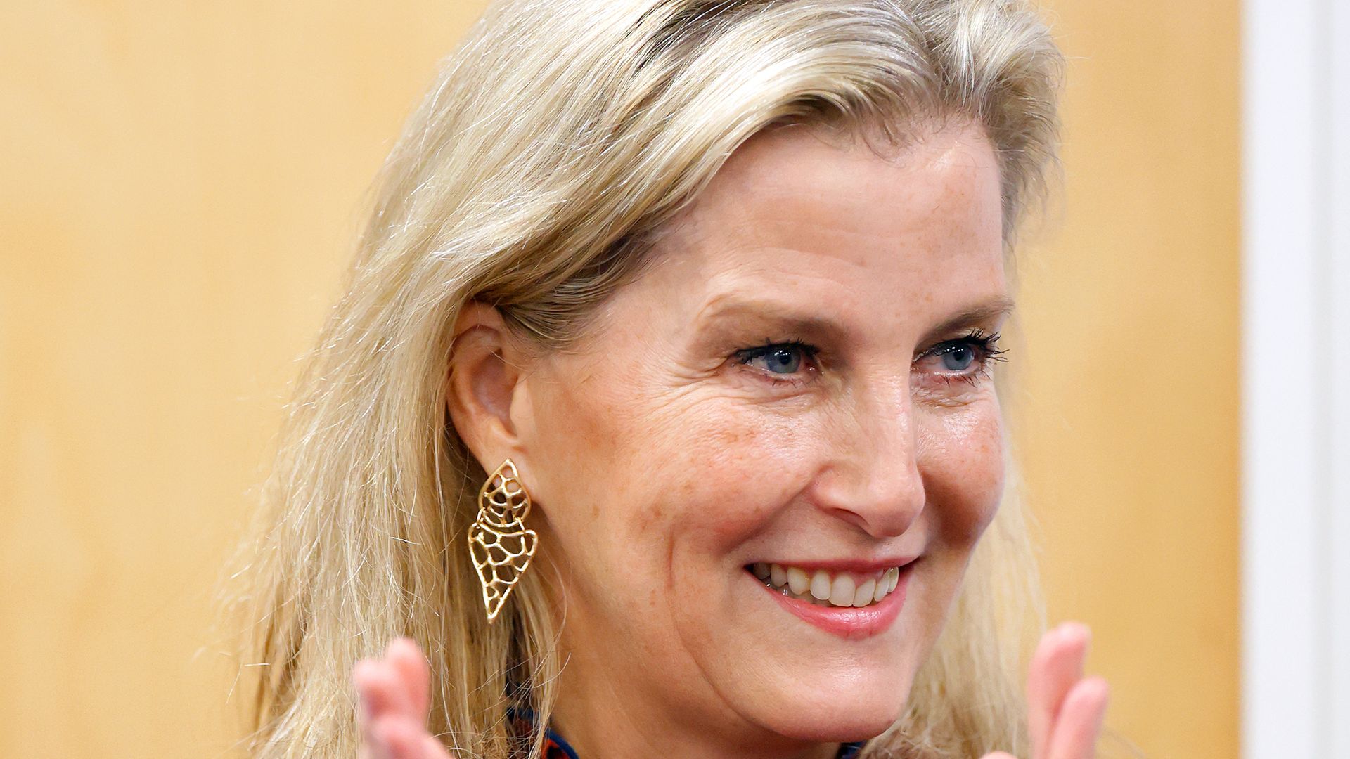 Sophie, Duchess of Edinburgh clapping in red printed dress