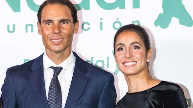 Rafa Nadal in a blue suit with his wife Mery Perello in a black velvet cut out dress