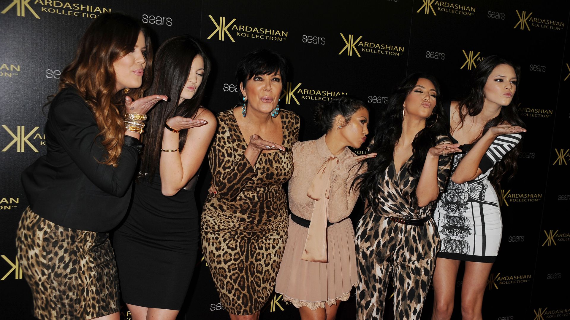 Kourtney Kardashian, Kylie Jenner, Kris Jenner, Kourtney Kardashian, Kim Kardashian, and Kendall Jenner stood together blowing kisses on a red carpet