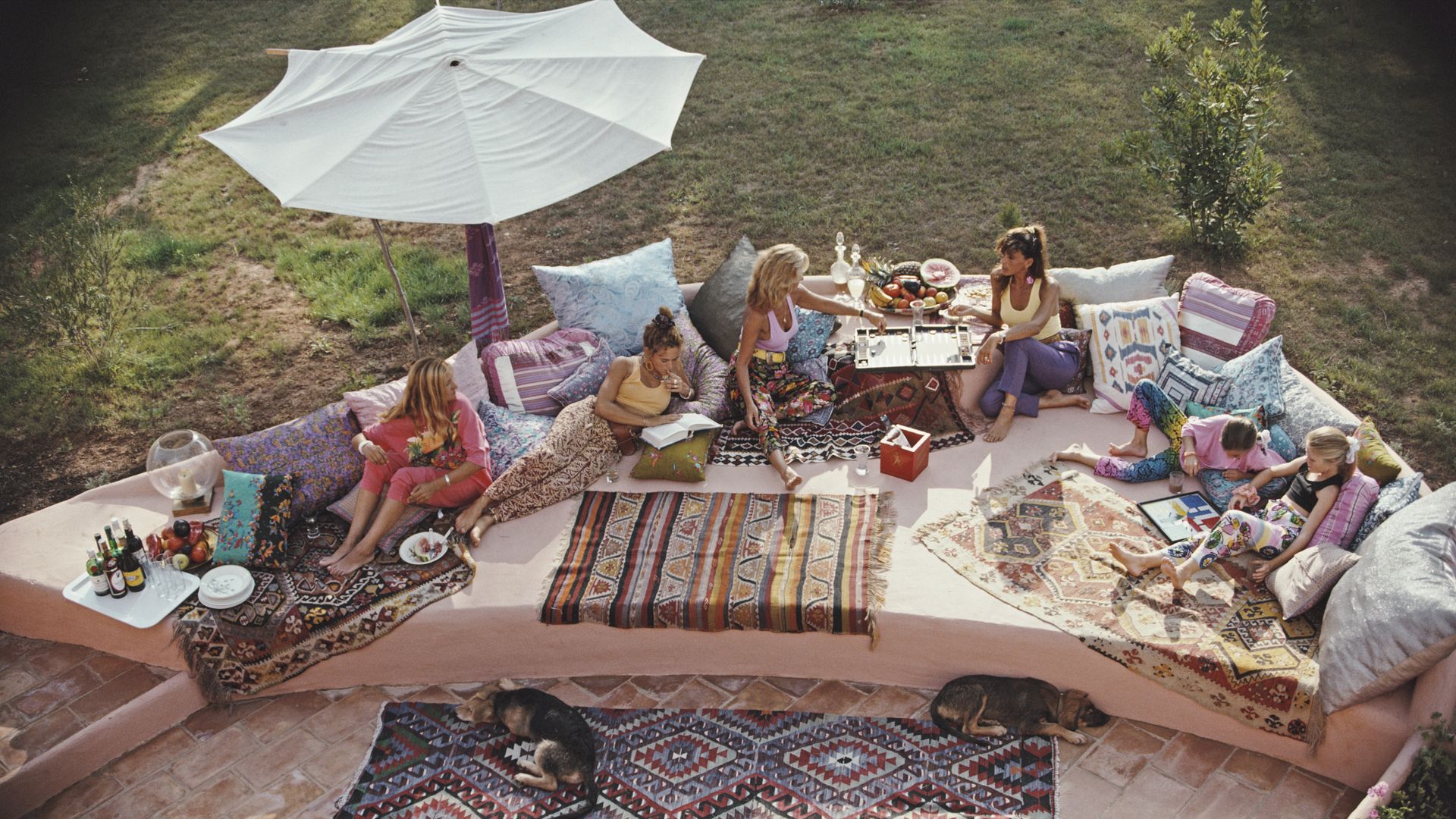 Artist Beth Batlle relaxes in the garden of her home 'Casa Rosada' with her friends Sylvia de Aragon, Mara Polo, and Carmen Uriach, Ibiza, Spain, August 1989. (Photo by Slim Aarons/Hulton Archive/Getty Images)
