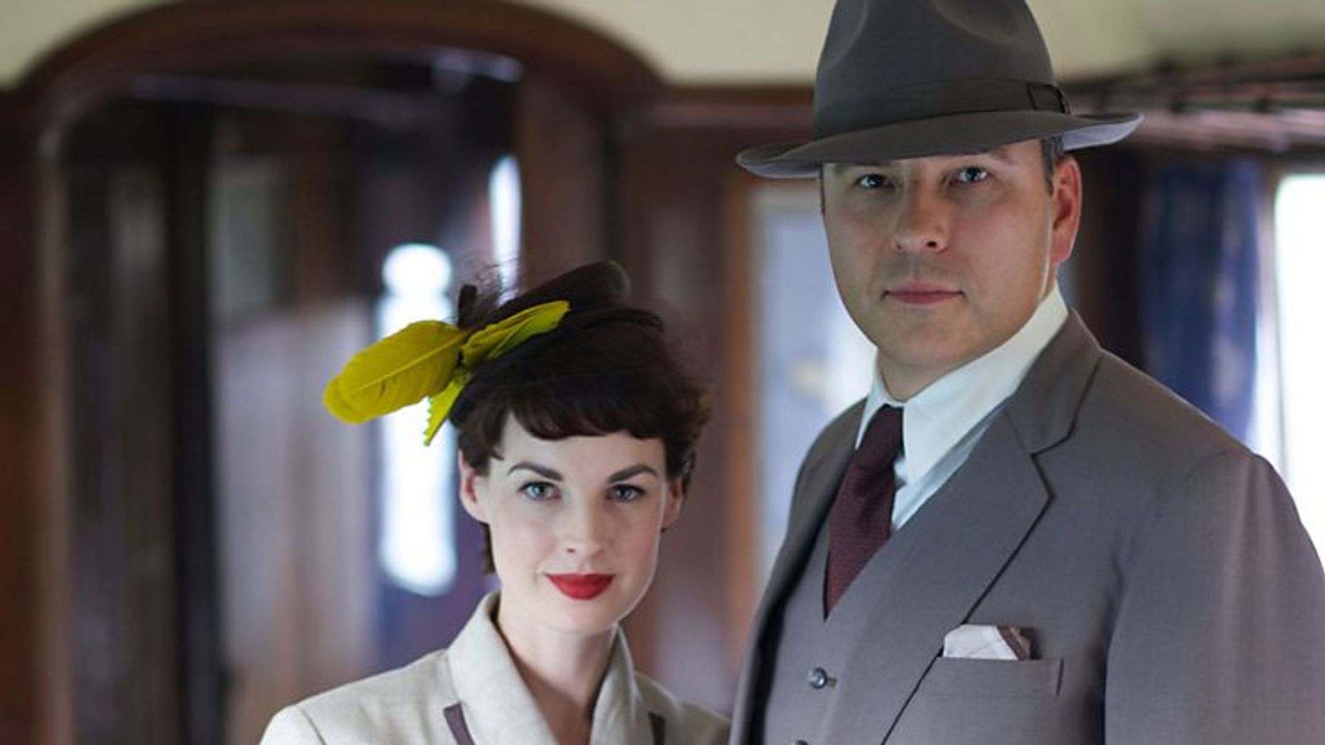 woman and man in period dress on train