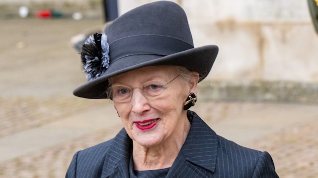Margrethe in black trilby hat and suit