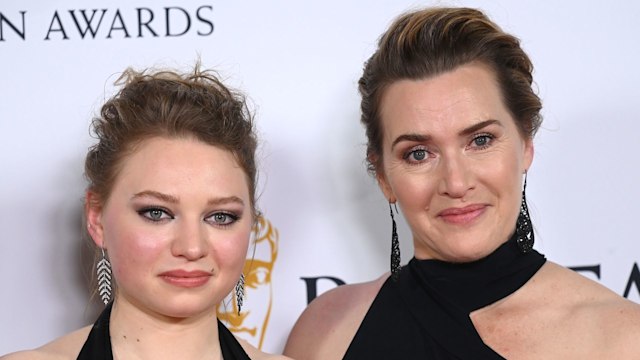 mother and daughter dress in black posing on red carpet