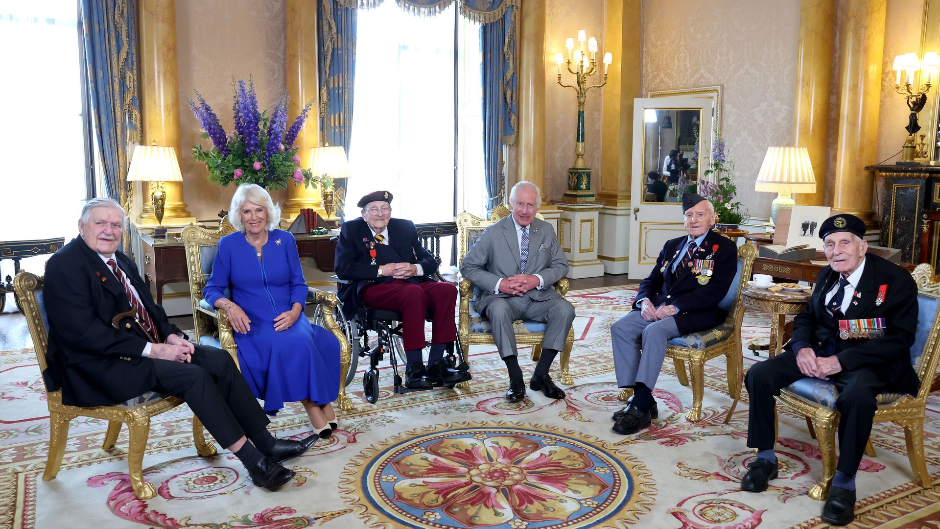 Queen Camilla and King Charles with four military veterans in Buckingham Palace