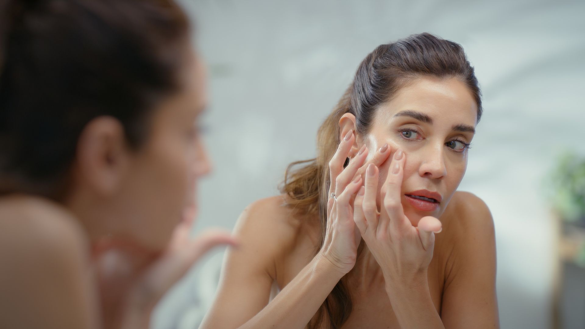 Mature woman, mirror and pimple with skincare in home, acne or reflection with routine in morning