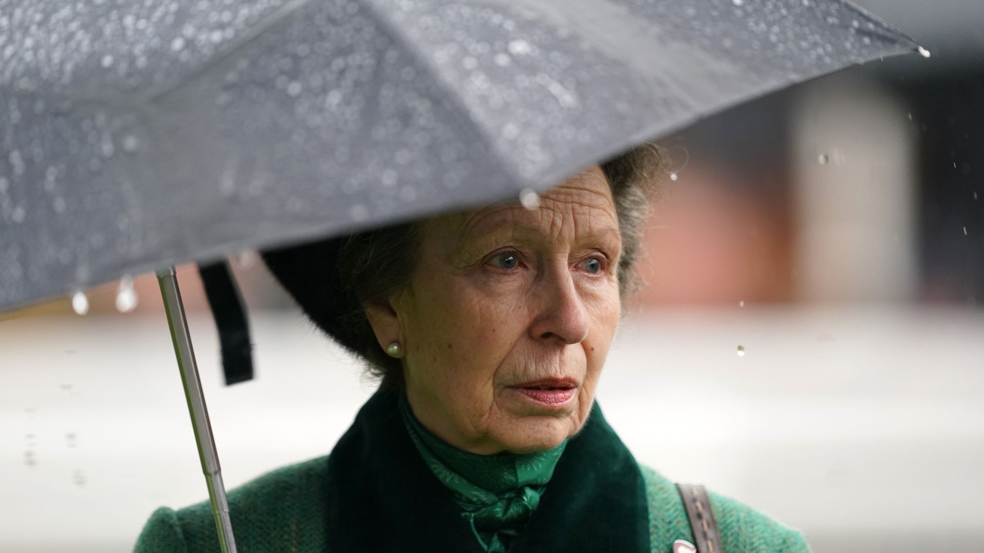 anne under an umbrella in green coat