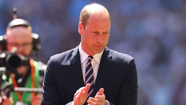 Prince William clapping with a stony expression