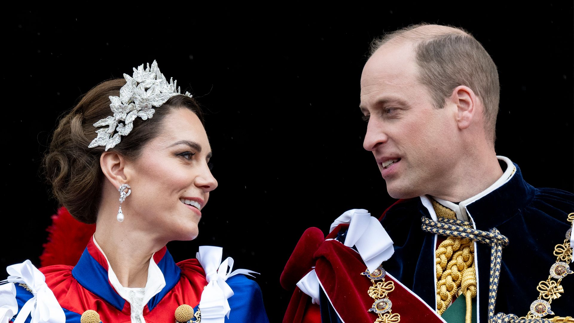 William and Kate looking at each other on palace balcony at the coronation