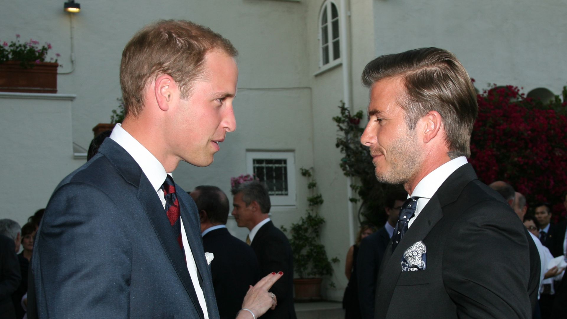 Prince William and David Beckham in suits talking to each other